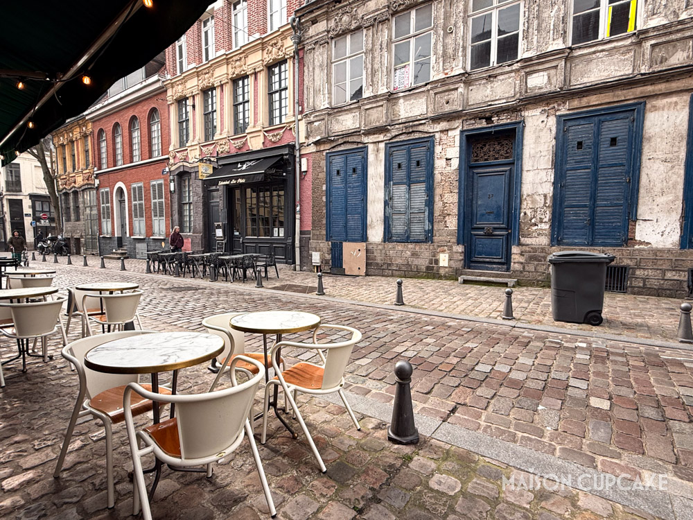Quiet cobbled street in Vieux Lille with mix of peeling facades and bright brickwork.