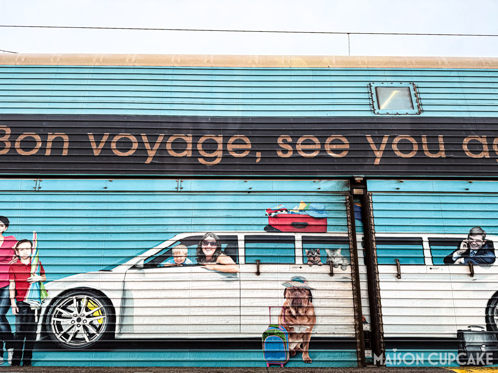 Brightly painted Channel Tunnel car coach with illustration of holiday makers in car captioned Bon Voyage