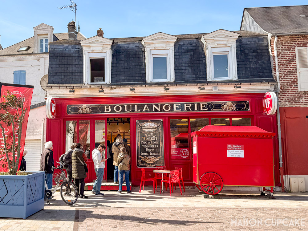 Bright red exterior of Victor Florent bakery in Le Crotoy with customers queuing, northern France