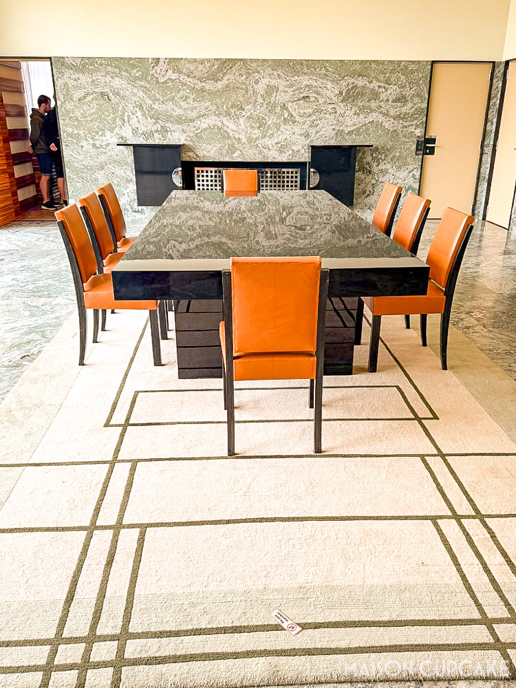 Dining room at Villa Cavrois with long table and minimalist geometric monochrome rug. 